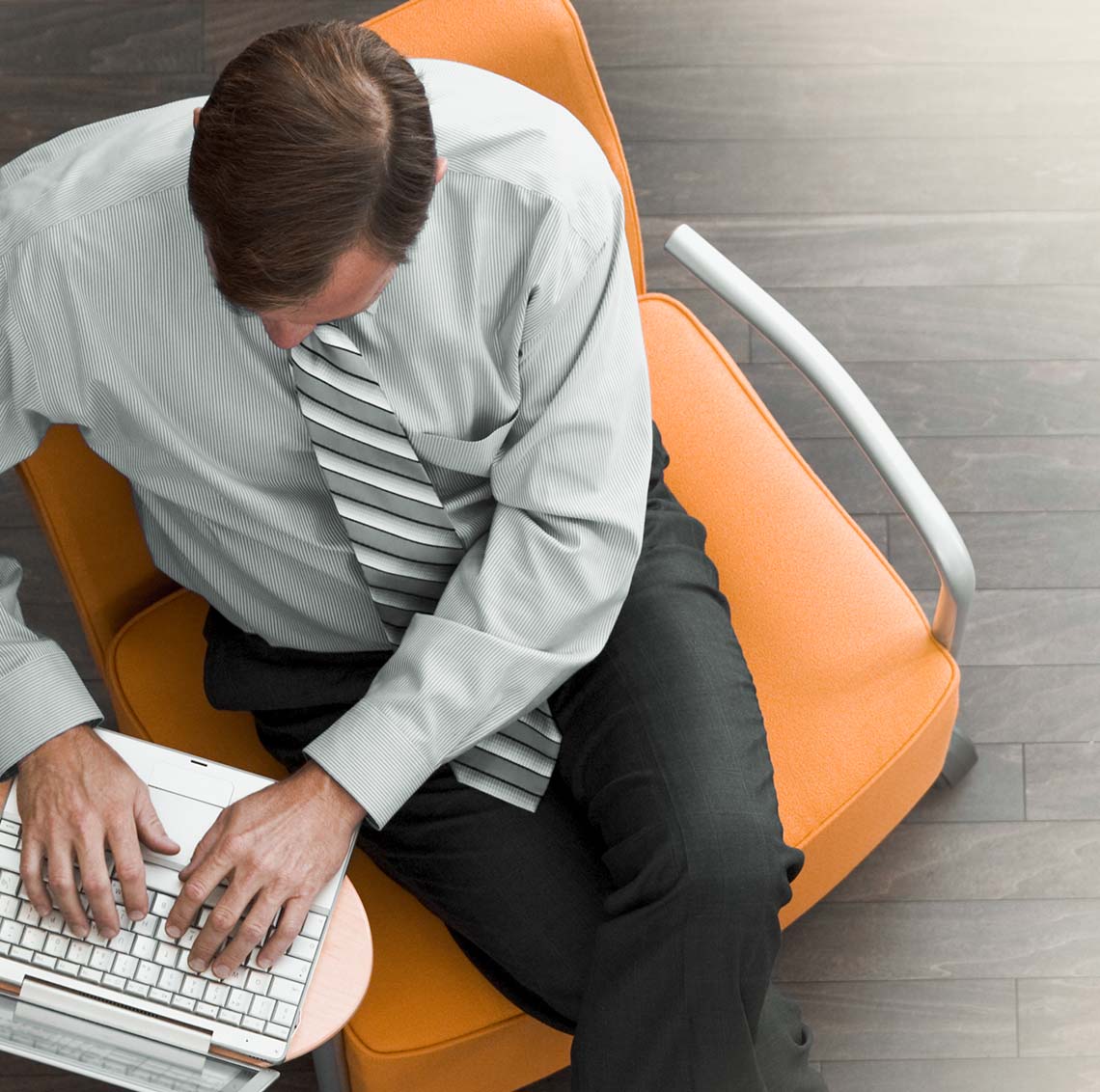 Person sitting in a chair working on a laptop