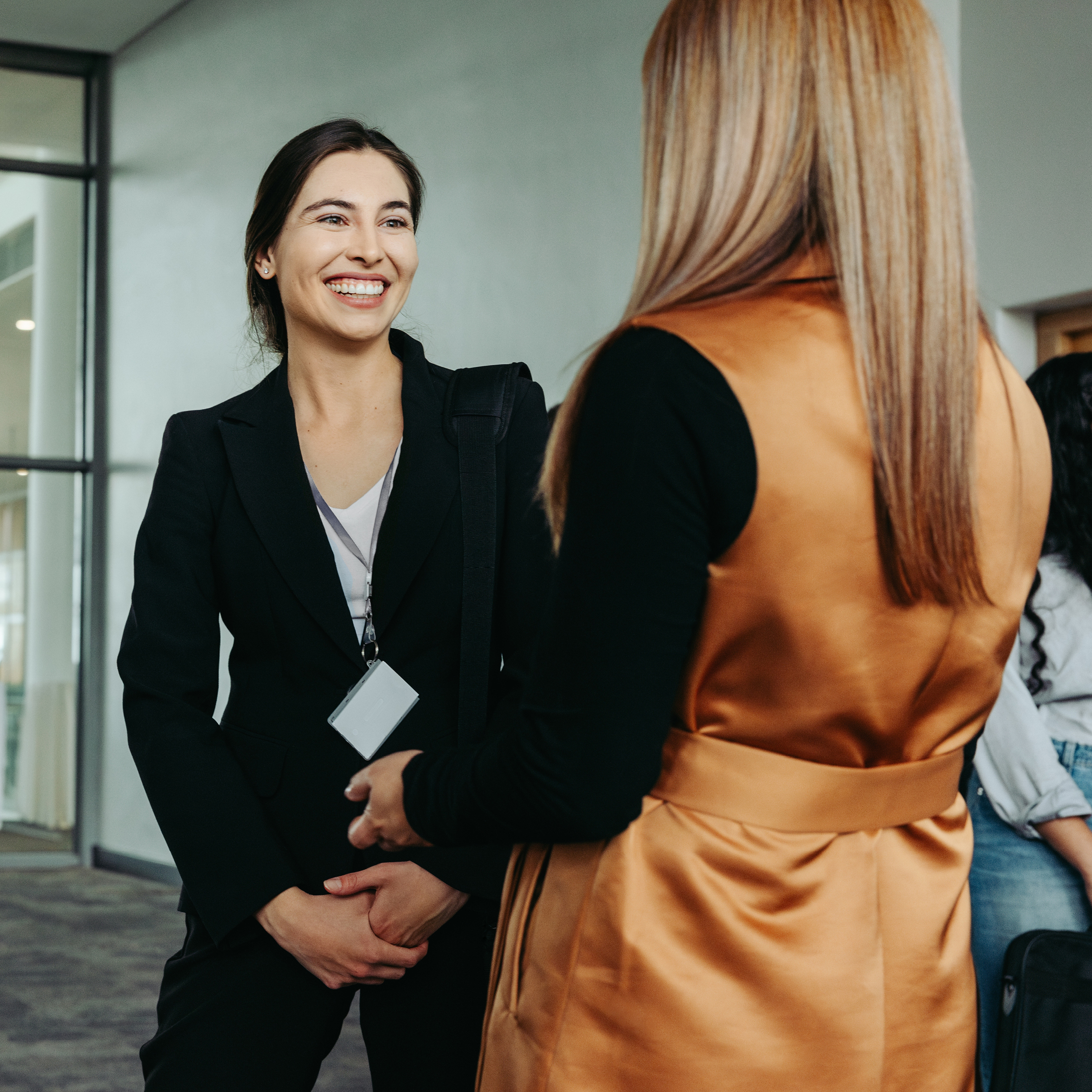 Two women at a conference talking to each other.