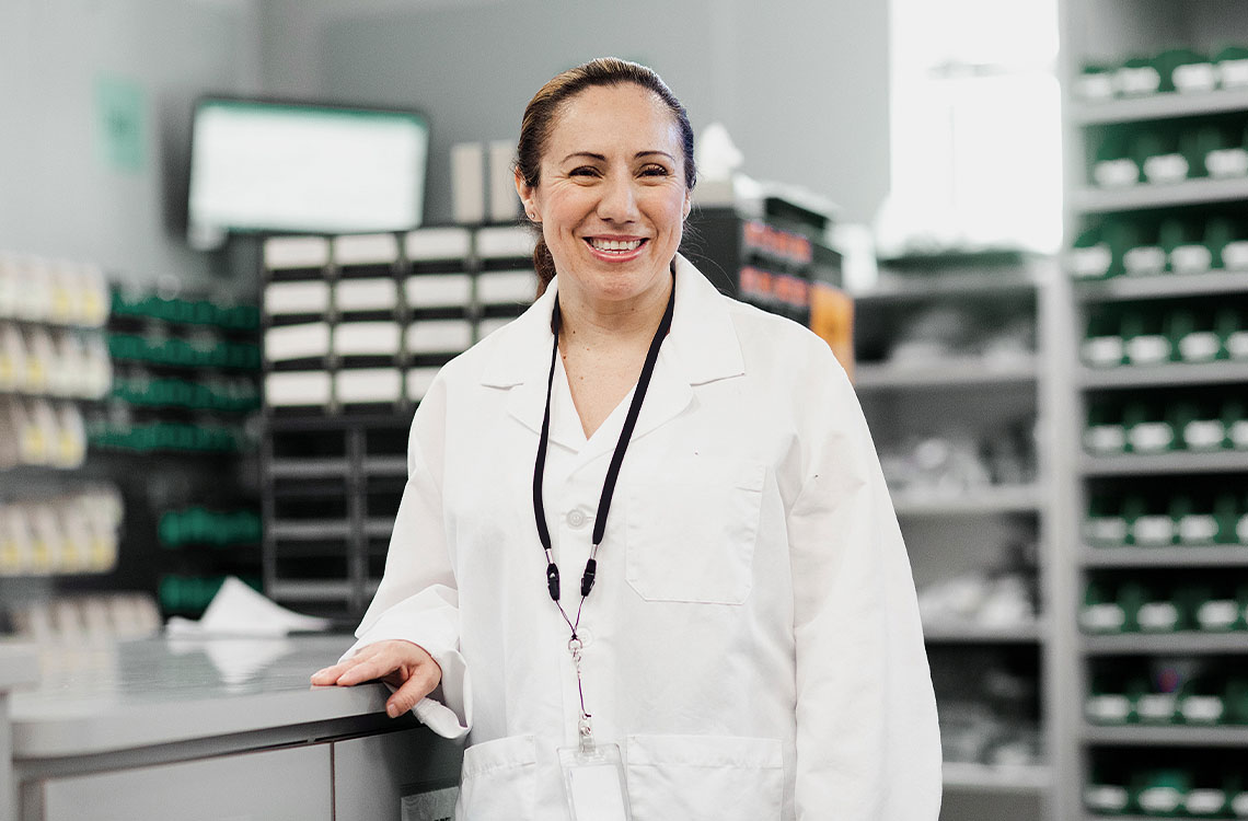 A smiling woman in a lab coat