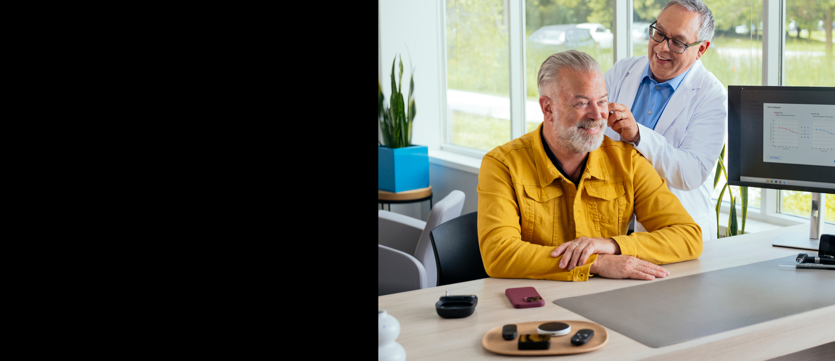 Man smiling being fit with hearing aids.